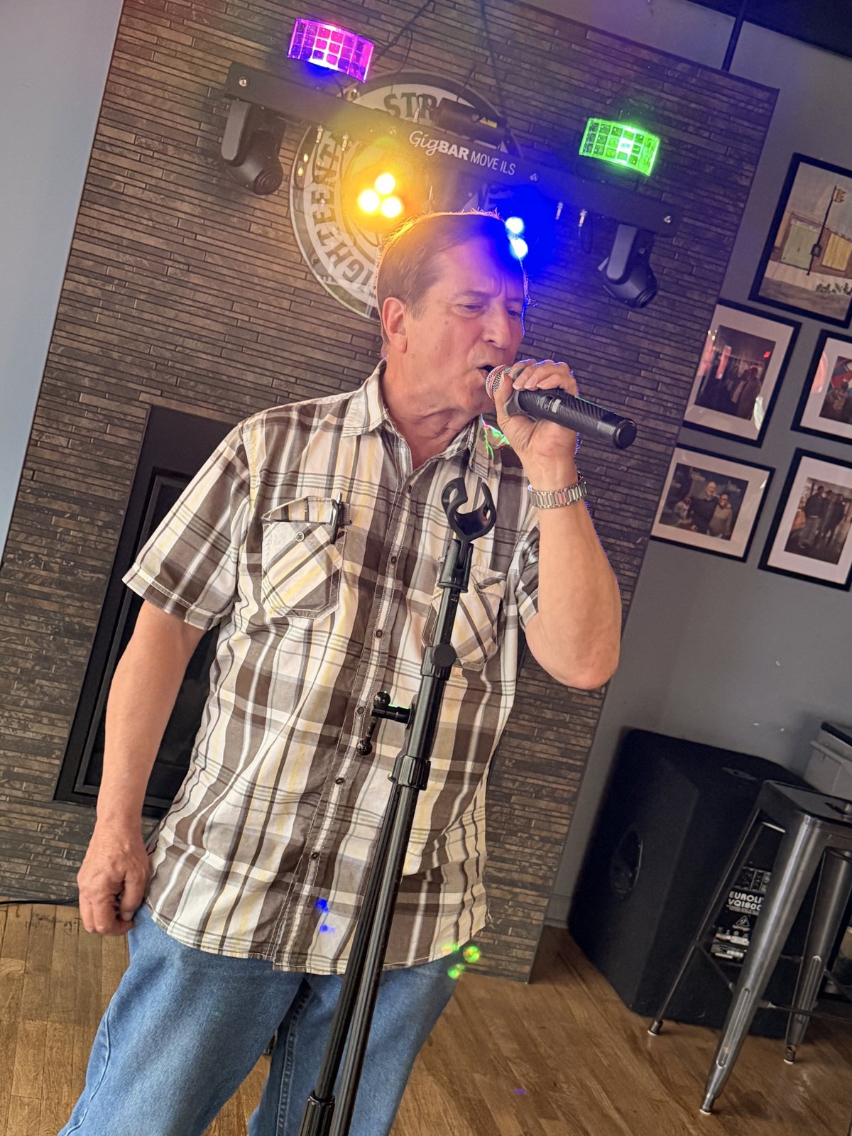 Singer at microphone with colorful stage lights at 18th Street Brewery karaoke Gary Indiana